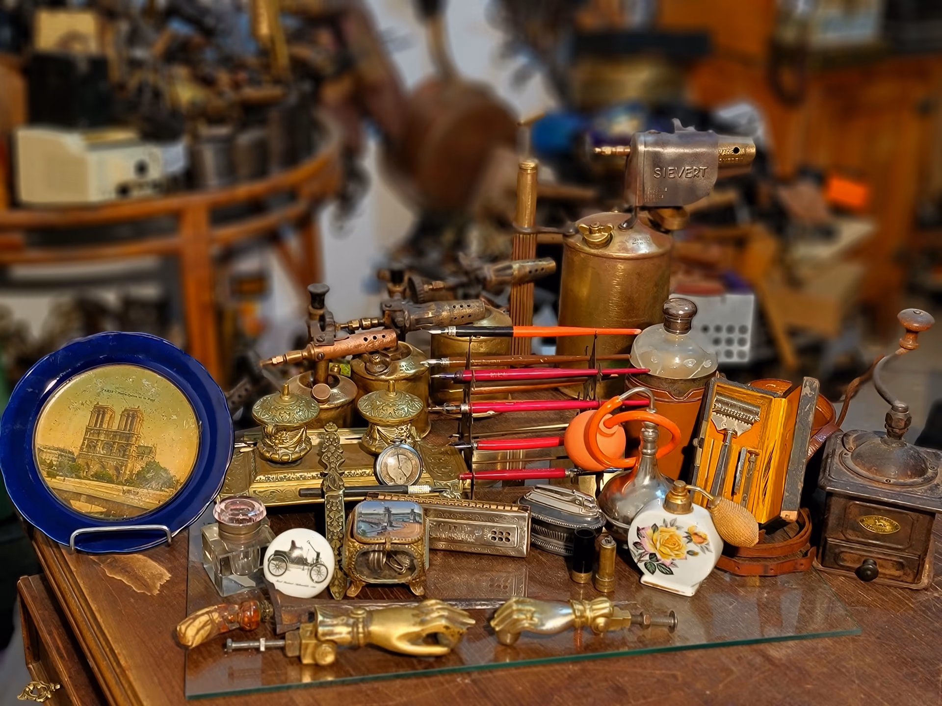 Objets anciens de la boutique : lampes en laiton, flacons, outils et curiosités réunis sur un comptoir
